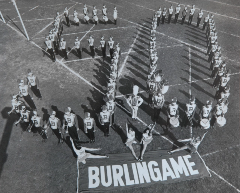 students standing to make a 50 on a football field